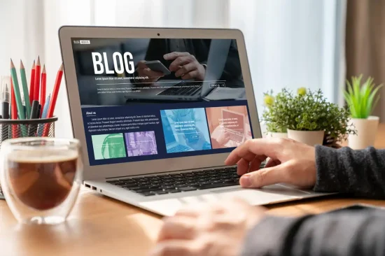 Empresário trabalhando no notebook em um blog para empresa, com café e plantas na mesa