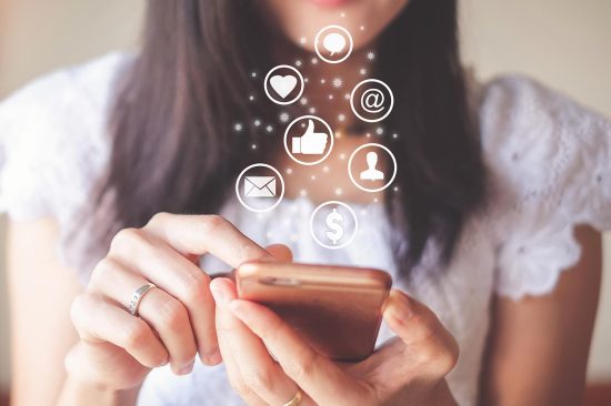 Mulher com celular conectado a redes sociais